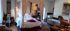 a bedroom with a canopy bed and a tub at La Coudonie in Sarrazac +37 photos