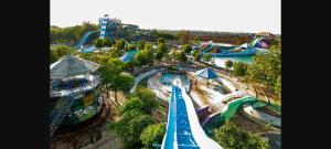 einen Luftblick auf einen Wasserpark mit Achterbahn in der Unterkunft Fortune Penthouse 11th floor with sky orbit swimming pool and gym in Rajkot