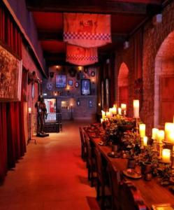 a long row of tables with candles in a room at Château des Princes " Fleur de Lys " in Sedan