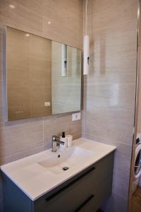 bagno con lavandino e specchio di Tramonto su Roma [ SELF CHECK-IN METRO A ] a Roma