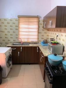 uma cozinha com um lavatório e um fogão forno superior em Jesam House em Suru Lere