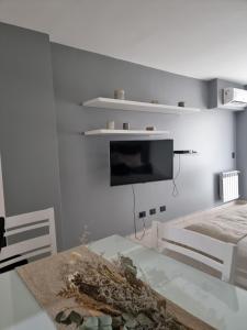 sala de estar con TV en una pared blanca en Un departamento de lujo en La Perla en Mar del Plata