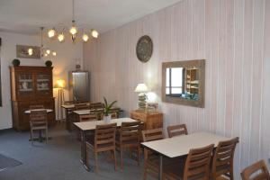 a dining room with tables and chairs and a mirror at Terminus Hôtel des 3 Vallées in Moutiers