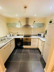 a small kitchen with a sink and a stove at Liverpool City Centre Modern Apartment fits 6 people in Liverpool