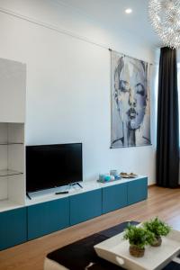 a living room with a tv on a blue cabinet at ApartOpera in Lviv