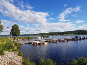 a bunch of boats are docked on a lake at Fin Villa nära insjön Burtäsket in Burträsk