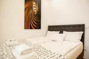 1 dormitorio con 1 cama con una foto en la pared en ApartOpera, en Leópolis
