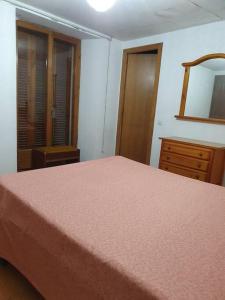 a bedroom with a bed and a dresser and a mirror at CASA NOSTRA piso-apto en Vilanova i la Geltrú-BCN in Vilanova i la Geltrú