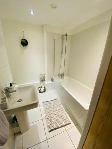 a white bathroom with a sink and a shower at Liverpool City Centre Modern Apartment fits 6 people in Liverpool +9 photos
