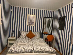 a bedroom with a bed with blue and white stripes at Fin Villa nära insjön Burtäsket in Burträsk