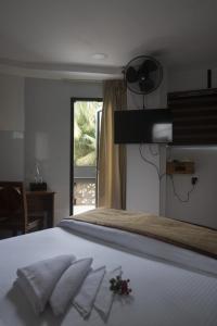 a bedroom with a bed with white sheets and a window at Magni Home in Cochin