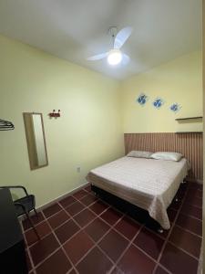 - une chambre avec un lit et un ventilateur de plafond dans l'établissement Casa á Beira-Mar Praião, Prainha, Barra de São João, à Barra de São João