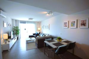 a living room with a couch and a table with chairs at Penthouse Apartment Tejita Beach in La Tejita