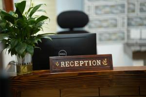 Znak z napisem "recepcja na biurku z komputerem" w obiekcie Magni Home w mieście Koczin
