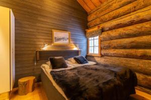 a bedroom with a bed in a log cabin at Kuukkeli Hirvas Suite in Saariselka
