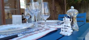 a blue table with plates and wine glasses on it at La Coudonie in Sarrazac