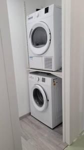two microwaves and a washing machine in a room at Appartement plein Centre Cauterets, Vacances et Cures in Cauterets
