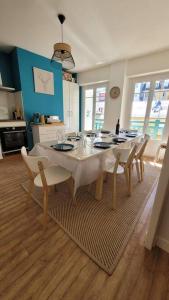 a dining room with a white table and chairs at Appartement plein Centre Cauterets, Vacances et Cures in Cauterets
