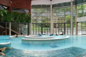 a large swimming pool with a fountain in a building at Appartement plein Centre Cauterets, Vacances et Cures in Cauterets