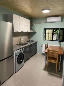 a kitchen with a table and a washing machine in it at Garden Hotel Pasanauri since 1892 in Passanauri