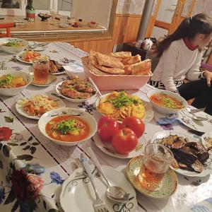 a table with plates of food on a table at Zaur Guest hause in Xınalıq