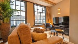 Una sala de estar con un sofá y algunas ventanas. en Locatie Downtown, en Ámsterdam