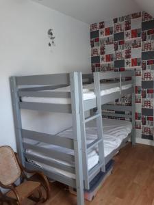 a bunk bed with white bunk beds in a room at chambres chez l habitant in Saint-Sauveur