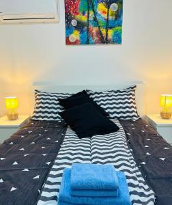 a bedroom with a bed with two blue pillows at Apartment In Time in Sesvete