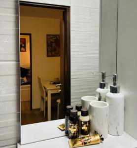 a bathroom with a mirror and a counter with some bottles at Apartment In Time in Sesvete