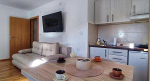 a kitchen and living room with a table and a couch at Soko City Center & Parking Free in Soko Banja