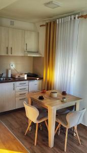 a kitchen with a wooden table and chairs at Soko City Center & Parking Free in Soko Banja