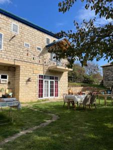 a table and chairs in front of a building at Lakeside Garden - Ismayilli Guest house in İsmayıllı