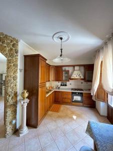 cocina grande con armarios de madera y fogones en Appartamento Garibaldi centro Sicilia., en Barrafranca