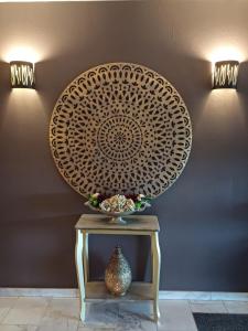 une table avec un vase sur elle à côté d'un mur dans l'établissement Park Hotel Airport, à Charleroi