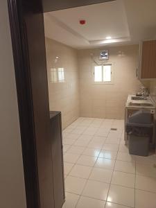 eine Küche mit weißem Fliesenboden und einem Fenster in der Unterkunft همم للوحدات السكنية - الرحيلي Jeddah in Al Kura