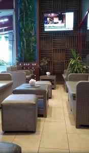 a restaurant with tables and chairs and a tv at Siar Apartment in Tirana