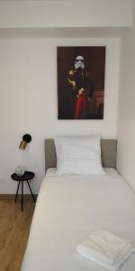 um quarto com uma cama branca e uma pintura na parede em La promesse - T3 Hyper centre em Abbeville