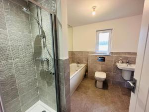 a bathroom with a shower and a toilet and a sink at Modern new build detached House near Edinburgh Airport in East Calder +14 photos