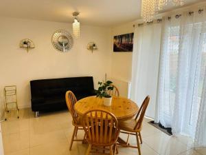 een eetkamer met een tafel en stoelen en een bank bij Modern new build detached House near Edinburgh Airport in East Calder