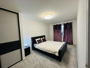 a bedroom with a bed and a window at Modern new build detached House near Edinburgh Airport in East Calder