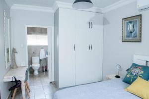 a bedroom with a bed and a bathroom with a toilet at Edwil's Place in Hartbeespoort