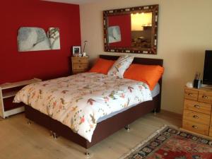 a bedroom with a bed with orange pillows and a mirror at Rothornblick in Arosa +58 photos