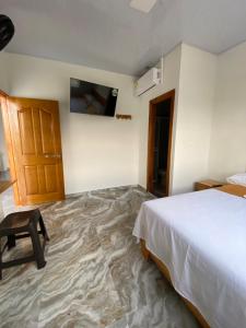 ein Schlafzimmer mit einem Bett und einem TV an der Wand in der Unterkunft Hotel EGIPTO in Apartadó