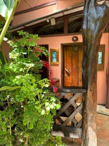 una casa con una puerta de madera y algunas plantas en Playa Negra Brewing Beachfront Hotel, en Puerto Viejo