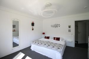 a white bedroom with a bed and a mirror at Haus Anna-Marie in Feldberg