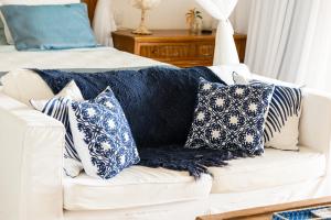 a white couch with blue and white pillows on it at Casa Mandala Corumbau in Corumbau