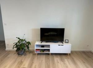 a living room with a flat screen tv on a white cabinet at L’Amistouso in Vedène