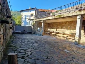 Casa Magdalena: mar y montaña في Adino: شارع حجري فيه كراسي وجسر