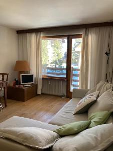 a living room with a bed and a large window at NIGRITELLA in Madonna di Campiglio