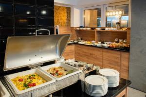 a kitchen with a buffet of food in a restaurant at Hotel Polonia PARK Medical Center & Spa in Busko-Zdrój